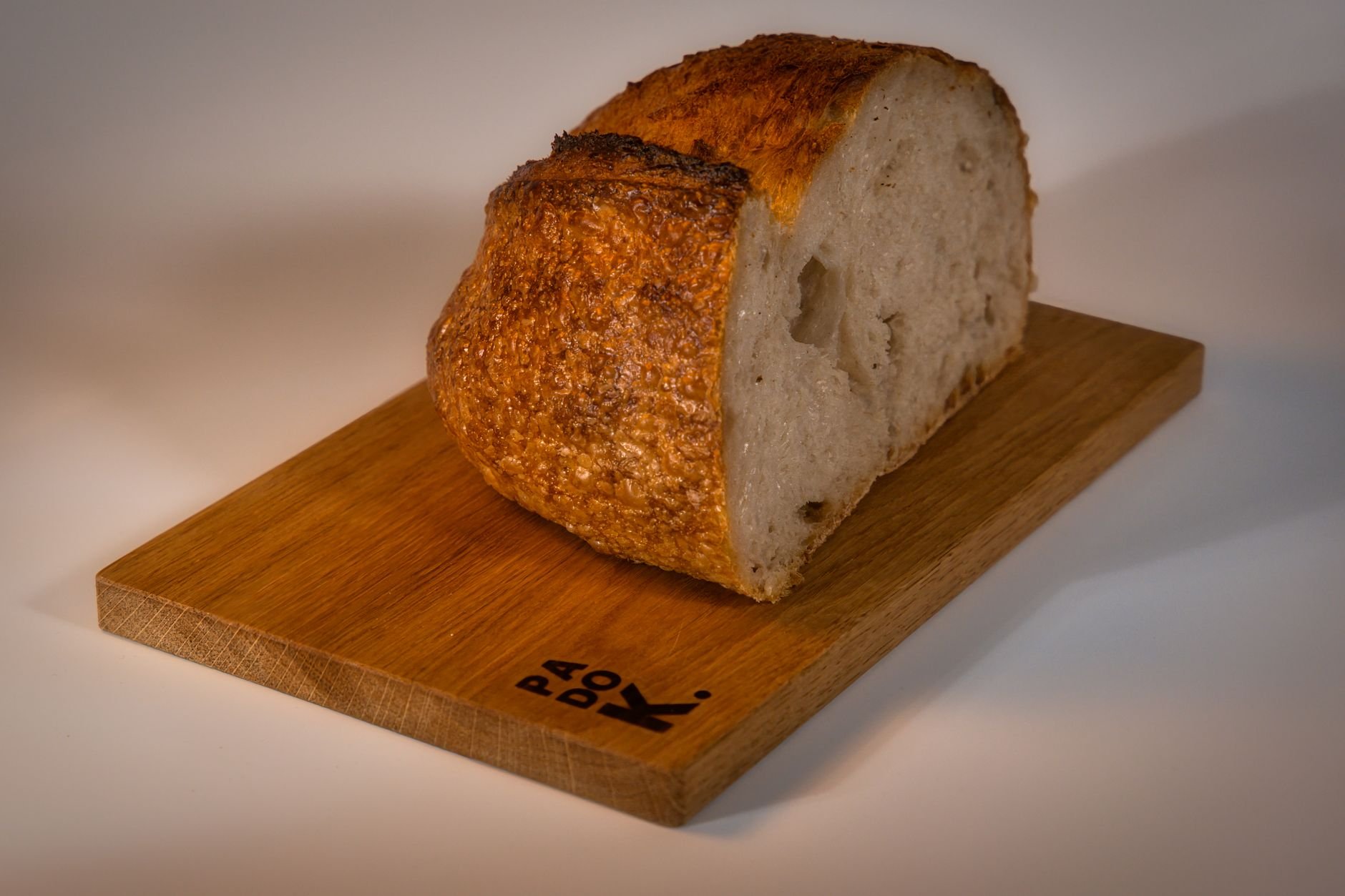 Close-up of freshly baked artisan bread on a wooden cutting board showcasing texture and crust.
